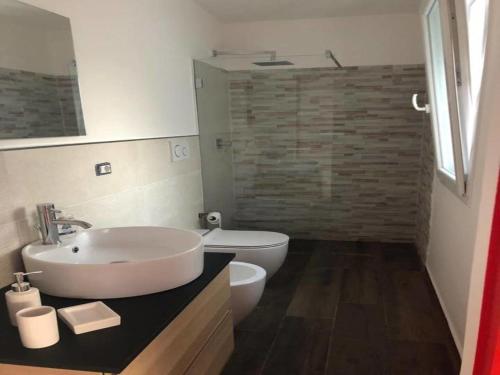 a bathroom with a white sink and a toilet at Villa by the sea - in full relaxation - Air conditioned - Wi-fi in Fontane Bianche
