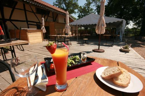 une table avec une assiette de nourriture et un verre de jus d'orange dans l'établissement Domaine des Brouilles, à Malafretaz