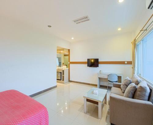 a living room with a couch and a table at Citrus-House com Hotel in Bogor
