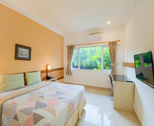 a bedroom with a large bed and a window at Citrus-House com Hotel in Bogor