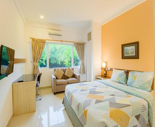 a bedroom with a bed and a couch and a window at Citrus-House com Hotel in Bogor