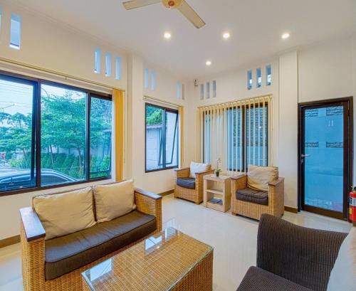 a living room with couches and a table and windows at Citrus-House com Hotel in Bogor