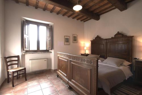 1 dormitorio con cama, ventana y silla en Agriturismo Acero Rosso, en Civitella di Romagna
