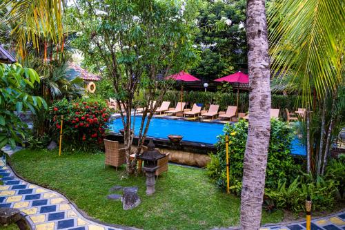 a swimming pool with lounge chairs and a resort at Rumah Mertua Heritage in Yogyakarta
