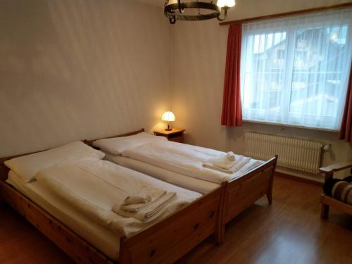 two beds in a bedroom with a window at Aurora 2 in Leukerbad