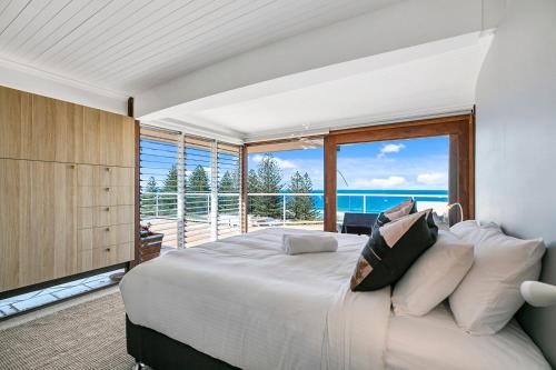 a bedroom with a large bed and a large window at Seascape in Sunshine Beach