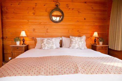 a bedroom with a large white bed with wooden walls at Glenlowren in Dixons Creek