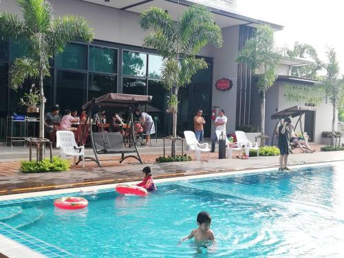 two children playing in a swimming pool with frisbees at J.P.GRAND HOTEL in Trat