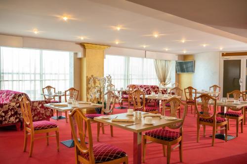 a dining room with tables and chairs and windows at U11 Hotel & SPA in Tallinn