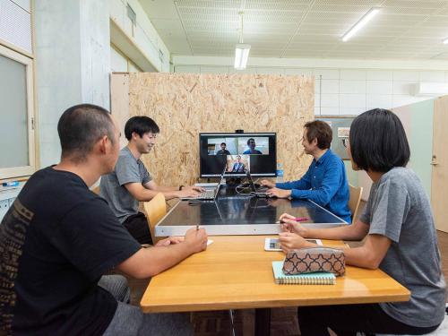 a group of people sitting around a table with a computer at YUKUSA OHSUMI UMI no GAKKO in Kanoya