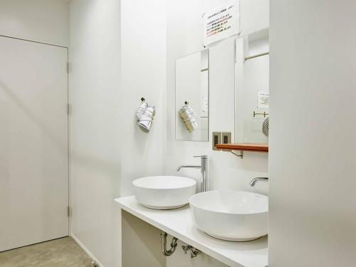 a bathroom with two white sinks on a counter at YUKUSA OHSUMI UMI no GAKKO in Kanoya