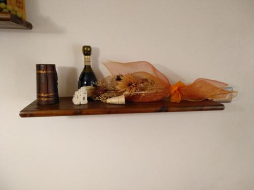 a wooden shelf with a bottle of wine and a bread at Casa Il Nido in Cagliari