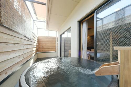 a hot tub in the middle of a room at Hanasuishou in Fuefuki