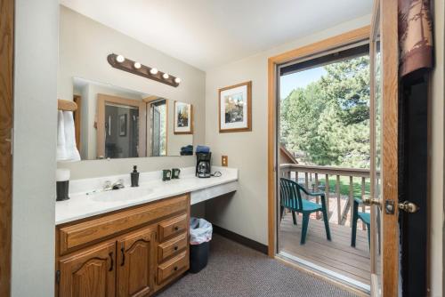 a bathroom with a sink and a view of a deck at 4 Seasons Inn on Fall River in Estes Park