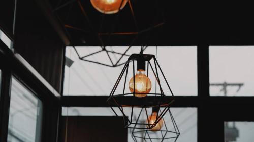 two lights hanging in a room with windows at Bansuay Bangkadi in Pathum Thani
