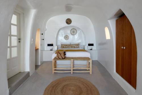 a bedroom with a bed in a white room at Filotera Suites in Oia