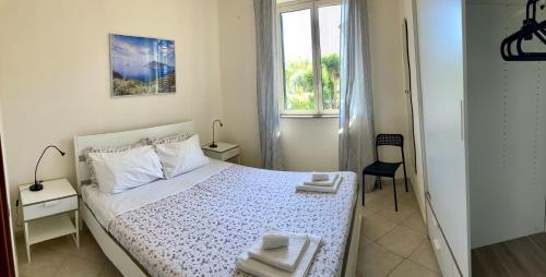 ein weißes Schlafzimmer mit einem Bett und einem Fenster in der Unterkunft Casa Vacanze Kezia in Torrenova