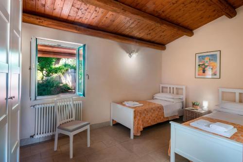 a bedroom with two beds and a window at Agriturismo Borgo degli ulivi in Canicattini Bagni