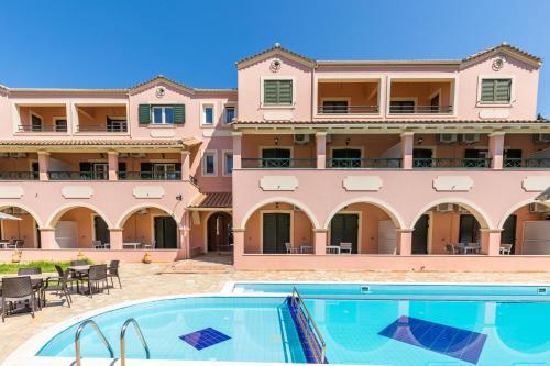 un hotel con piscina di fronte a un edificio di BELLA De LUX APTS a Ipsos