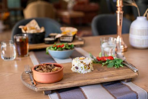 a wooden table with a plate of food on it at SUNOLUS VINEYARDHOUSe in Kayseri
