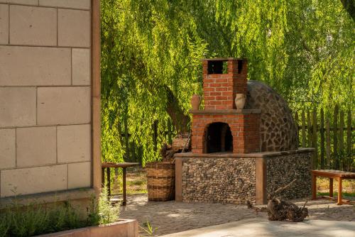a brick oven in a yard next to a tree at SUNOLUS VINEYARDHOUSe in Kayseri