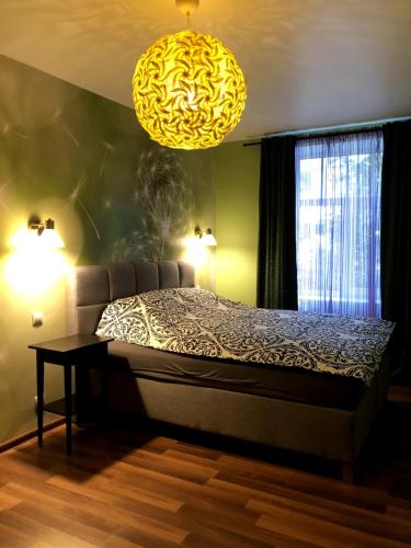 a bedroom with a bed and a chandelier at Green and quiet city center in Rīga