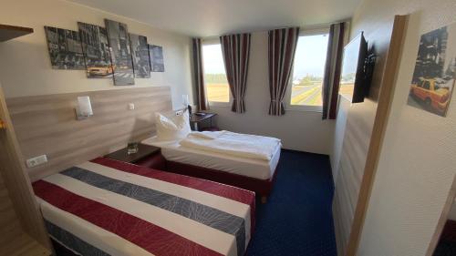 a hotel room with two beds and a window at Motel 44 in Geseke