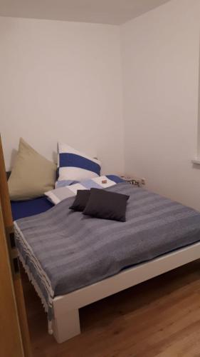 - un lit avec des draps et des oreillers bleus dans l'établissement gemütliche Ferienwohnung in der Oberlausitz, à Habrachćicy