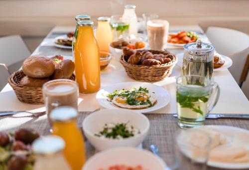 una mesa con platos de comida y botellas de jugo de naranja en Astral Palma Hotel, en Eilat