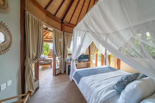 a bedroom with a bed with a mosquito net at Blue Lagoon Avia Villas in Nusa Lembongan