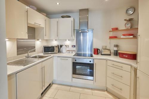 a kitchen with white cabinets and a stove top oven at Host & Stay - The Eskape in Whitby