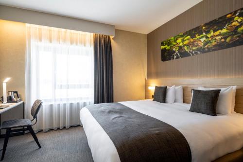 a hotel room with a large bed and a window at Golden Lakes Hotel in Boussu-lez-Walcourt