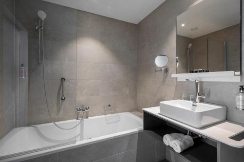 a bathroom with a tub and a sink and a bath tub at Golden Lakes Hotel in Boussu-lez-Walcourt