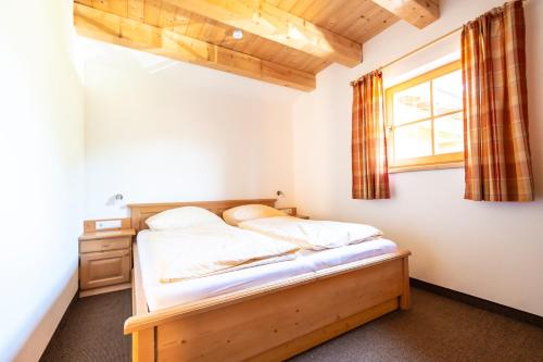 Schlafzimmer mit einem Bett und einem Fenster in der Unterkunft Erblehenhof in Forstau
