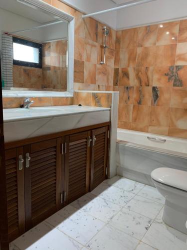 a bathroom with a sink and a tub and a toilet at Villa Denise in Yaiza