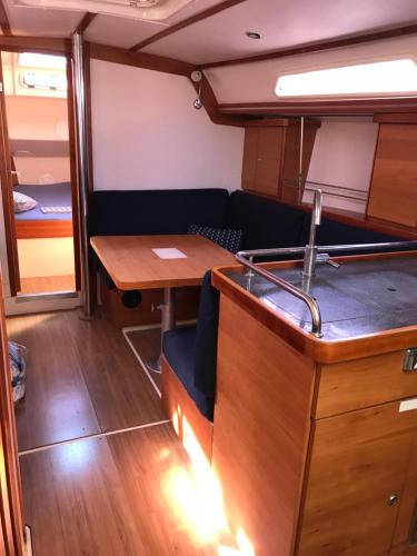 Sailing Yacht Armida Rhodes في بلدة رودس: غرفة معيشة مع طاولة وأريكة في قارب
