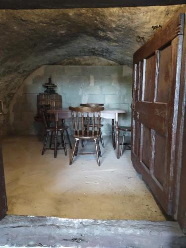 a room with a table and chairs in a cave at Káli Vineyard Estate in Köveskál