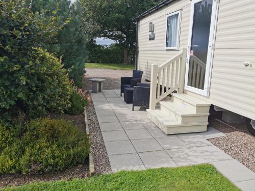 a patio with chairs and stairs next to a house at The Trotting Mare Holiday Lets - Adults Only in Wrexham