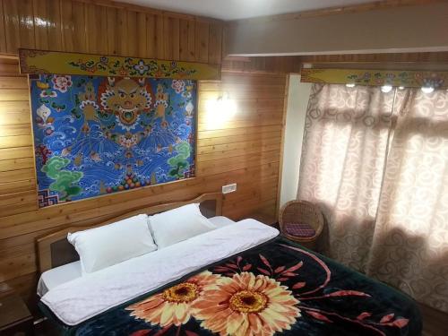 1 dormitorio con 1 cama con una pintura en la pared en Hotel Taktsang Darjeeling en Darjeeling