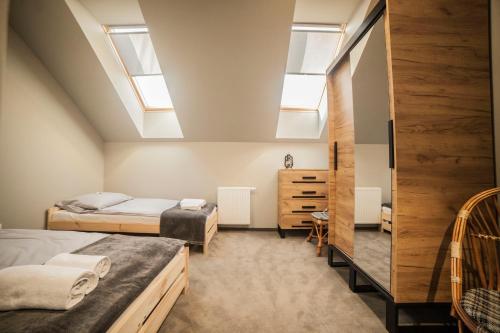 a attic bedroom with two beds and skylights at Hostel pod Cisem in Elblag