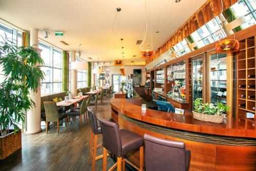un restaurante con bar, mesas y sillas en Hotel Restaurant Winkler, en Mürzzuschlag