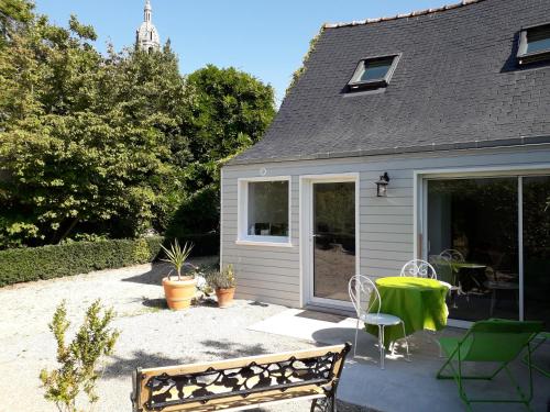 un patio d'une maison avec une table et des chaises dans l'établissement Gîte, Le Jardind'Eneour, spots de surf, plages et randonnées !, à Plonéour-Lanvern