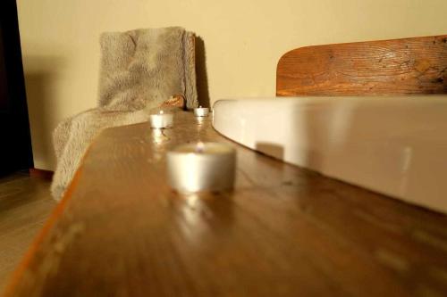 a wooden table with two candles on top of it at Romantica suite con vasca idromassaggio in Aosta