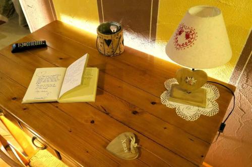 a table with a lamp and a book on it at Romantica suite con vasca idromassaggio in Aosta