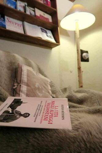 a book sitting on top of a bed with a lamp at Romantica suite con vasca idromassaggio in Aosta