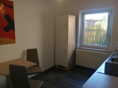een keuken met een koelkast, een tafel en een raam bij Gästewohnung in Cottbus-Klein Ströbitz in Cottbus