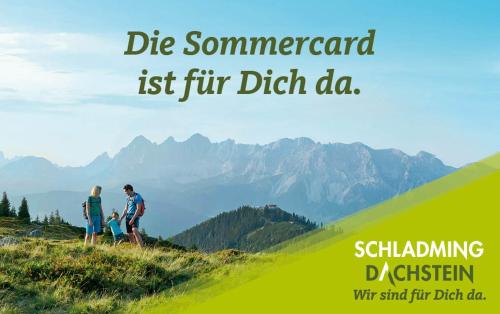 two people walking on a hill with mountains in the background at Erblehenhof in Forstau