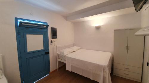 Cette petite chambre comprend un lit et une porte bleue. dans l'établissement Little Troll House 2, Golden Beach,, à Chrissi Akti