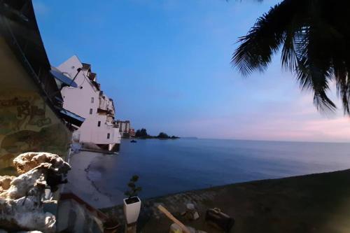 a house on the side of a body of water at Port Dickson PD Beach Front Homestay in Port Dickson