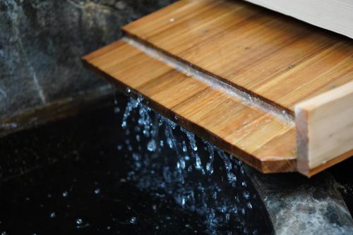 a stream of water coming out of a wooden board at かわもと別邸９２６ in Yufuin